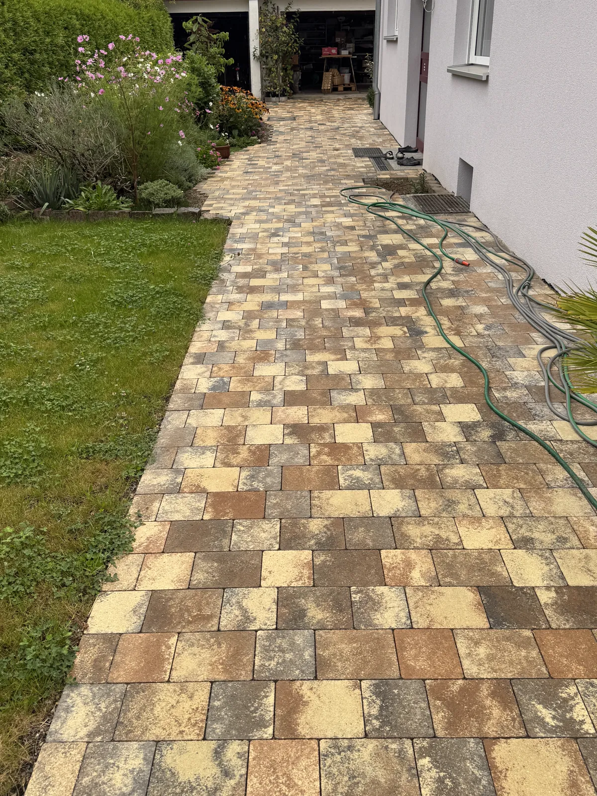 Weg aus warmem Pflaster neben einem Rasen
